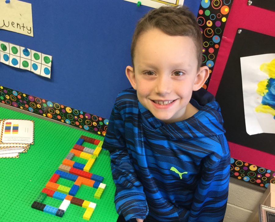 Smiling child with lego in classroom